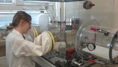 badania laboratoryjne  - fotografia osoby wykonującej prace w komorze próżniowej